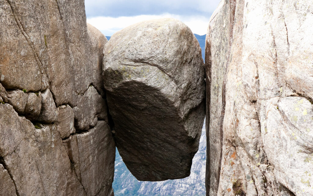 Photo of a boulder stuck between two massive rock faces.