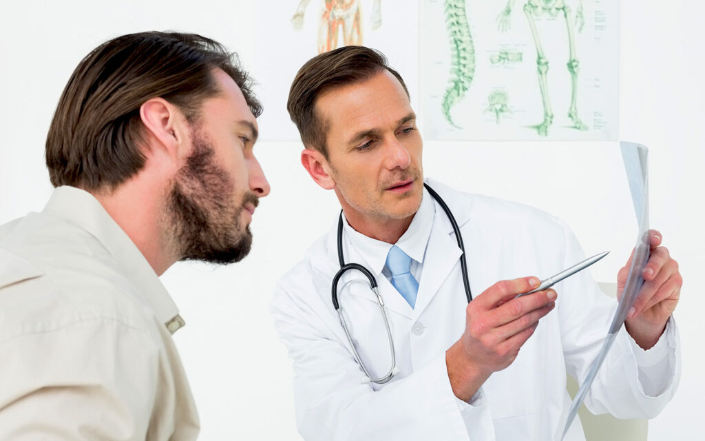 Image of a doctor discussing the 4 Stages to Passing Kidney Stones to a man.